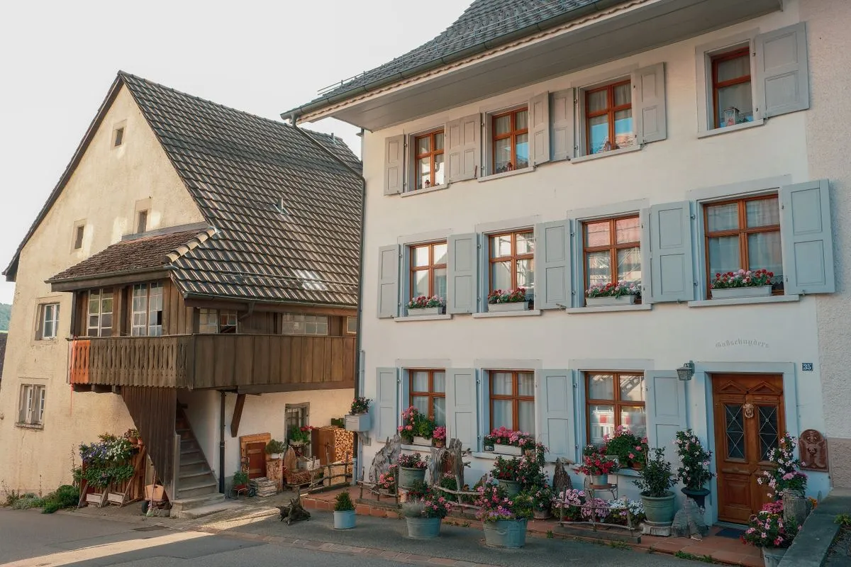 Maisons de village traditionnelles avec volets et jardinières fleuries, le type de meublé de tourisme soumis aux taxes locales en France