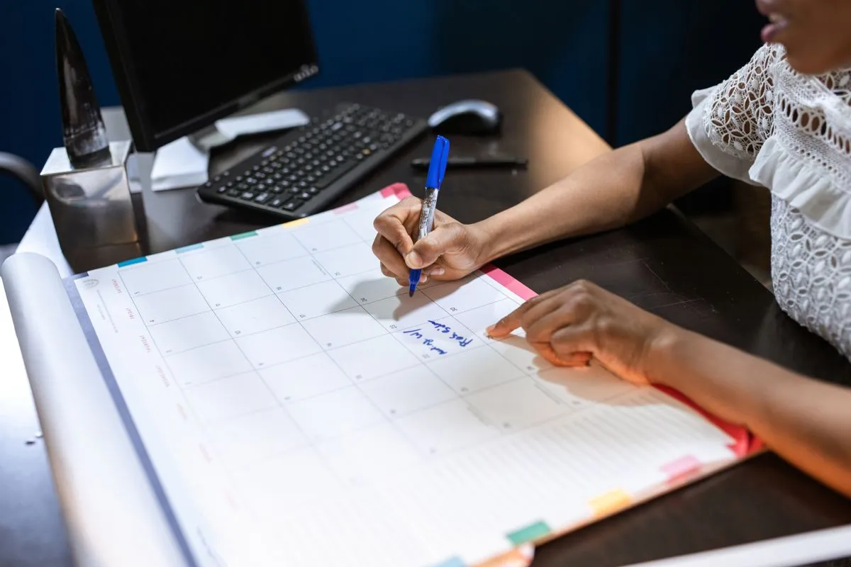 Person planning length-of-stay discounts in a desk calendar