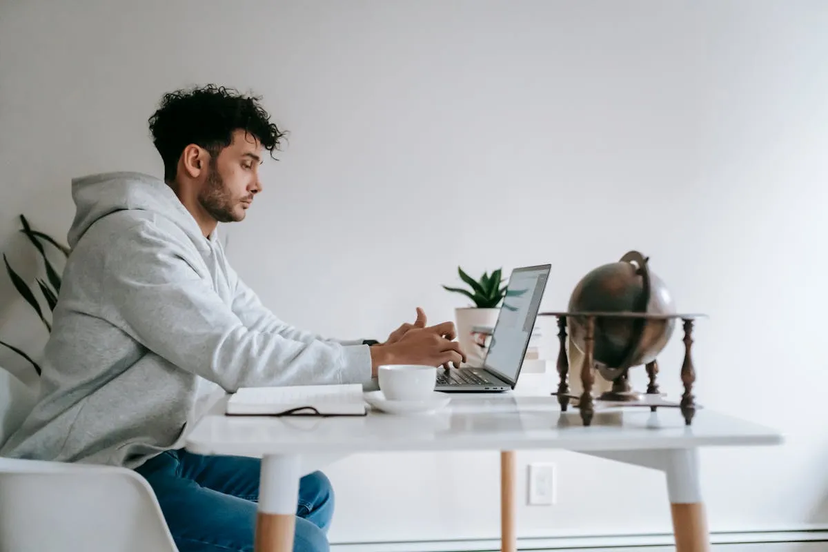 Person working on laptop in a cozy home office managing vacation rentals