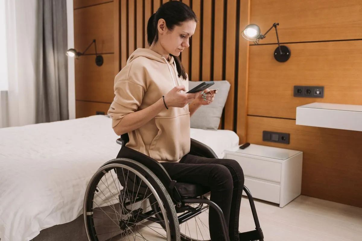 Woman in a wheelchair using a smartphone in an accessible space