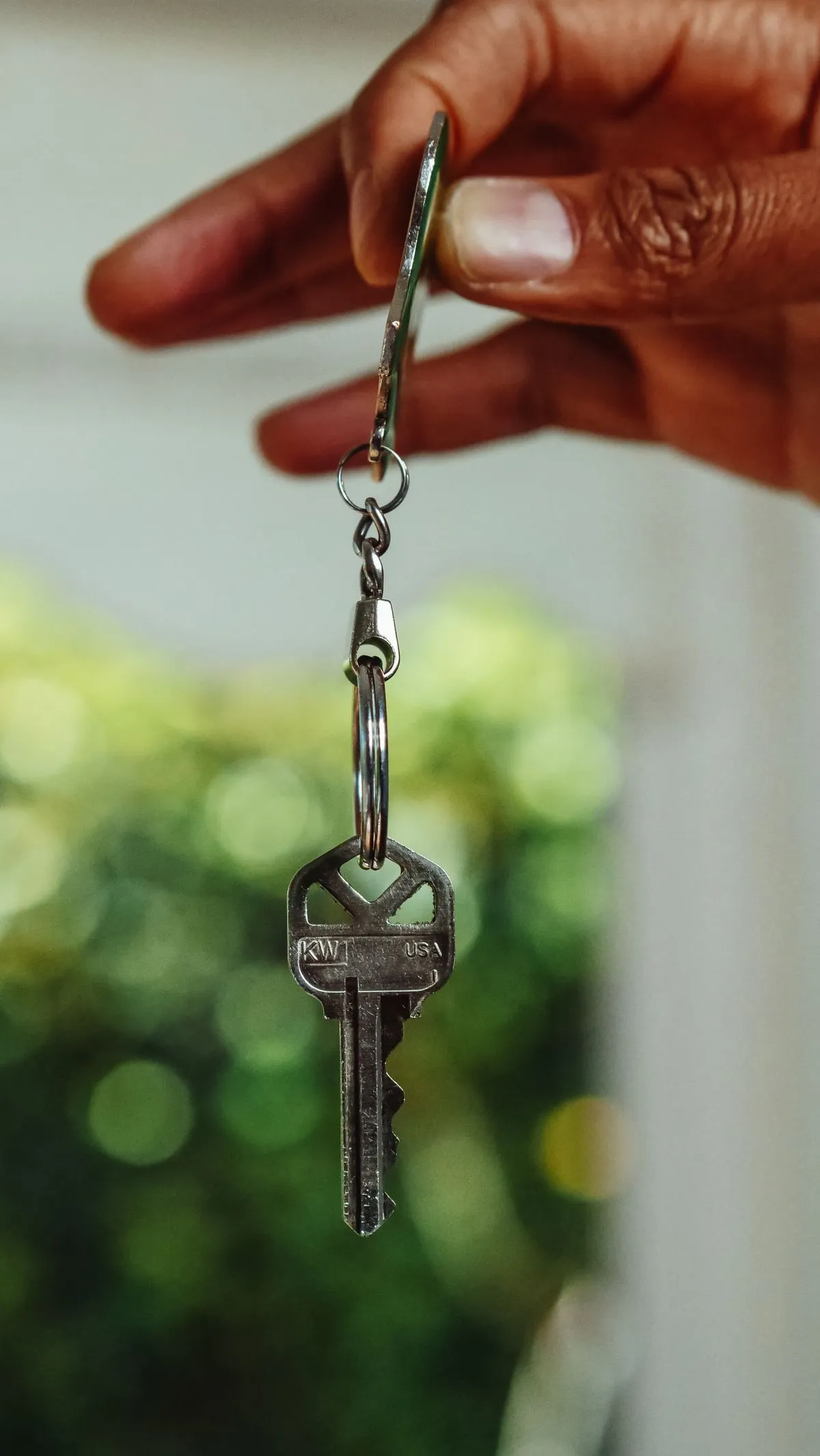 Hand holding a house key symbolizing checkout and key return