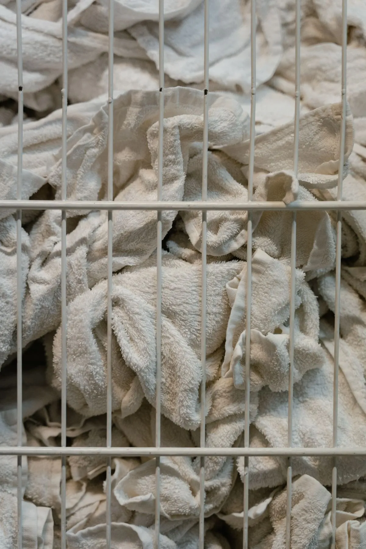 White towels in a basket among vacation rental consumables